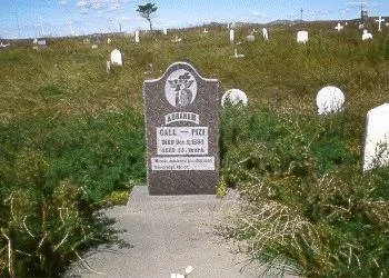 A dark headstone in a grassy prairie cemetery inscribed "Abraham Gall – Pizi, died Dec. 5, 1894," with white grave markers around it.
