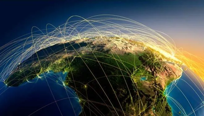 Satellite-style view of Africa at night from space, with glowing city lights and bright arcs of light connecting points across the continent and globe.