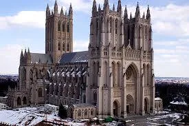 Aerial view of the Washington National Cathedral's Gothic towers and long nave, with snow on the surrounding grounds.