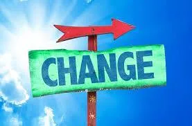 A green wooden sign reading "CHANGE" with a red arrow pointing right, set against a bright blue sky and sun.