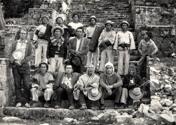 Black-and-white 1971 photo of Quechua men in ponchos and brimmed hats gathered on ancient stone steps, with Phil Lane Jr. and elder Meleton Gallardo among them.