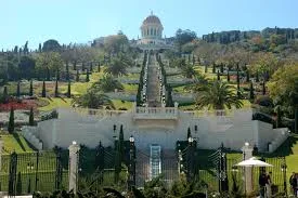 Terraced gardens with palm trees and manicured lawns rising up a hillside to a domed shrine, on Mt Carmel in Haifa.