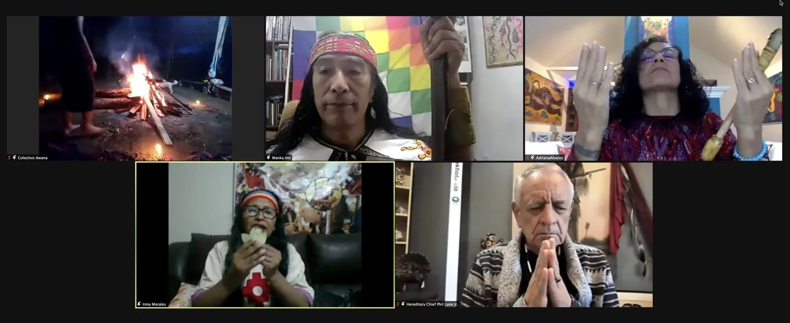 Video call with five participants: a ceremonial fire at night, a man in a headband before a wiphala flag, a woman raising her hands, a woman holding leaves, and Hereditary Chief Phil Lane Jr. praying.