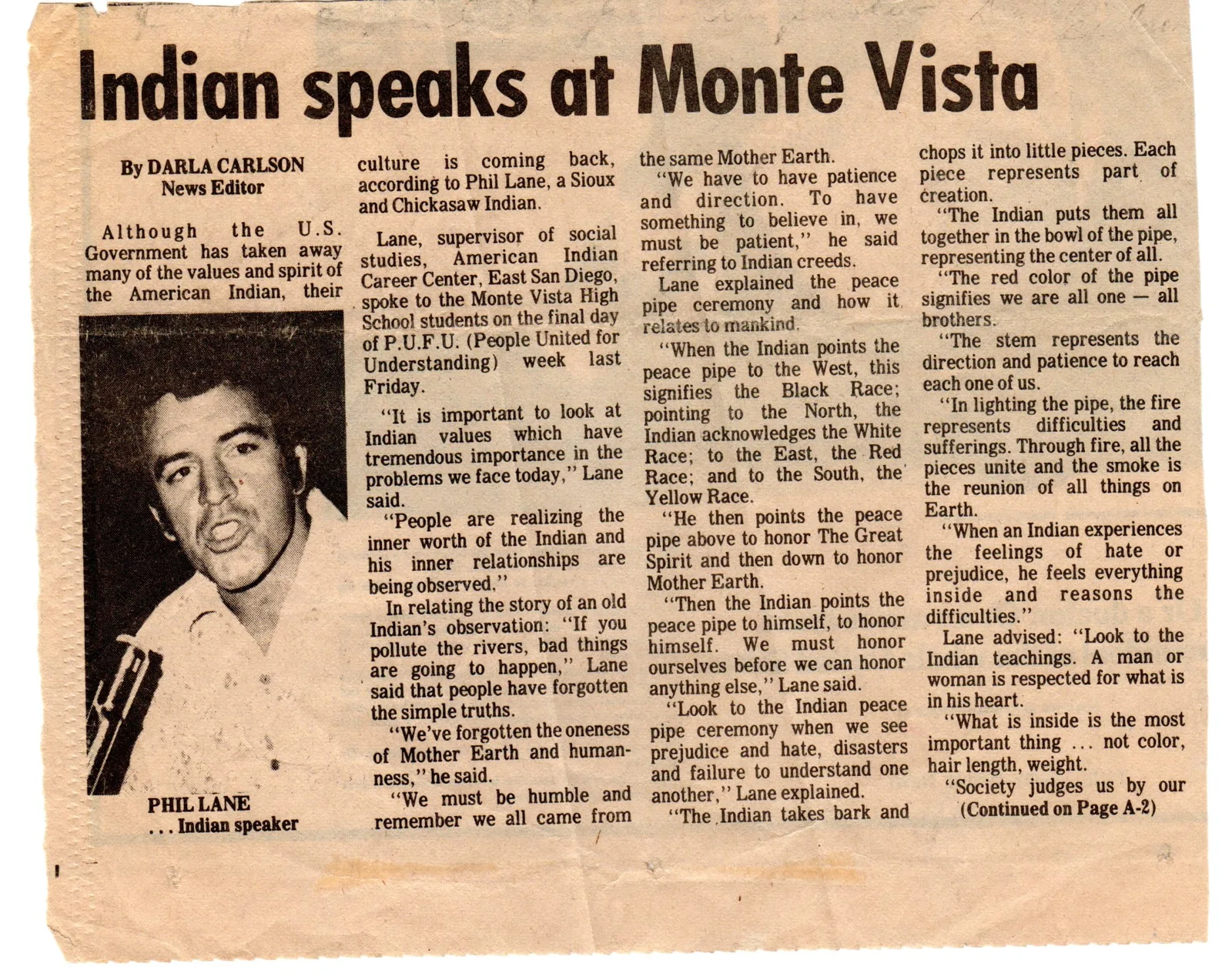 Yellowed newspaper clipping headlined "Indian speaks at Monte Vista," with a photo of a young Phil Lane speaking, reporting his talk to high school students on Indian values and the peace pipe.