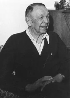 Black-and-white photograph of Vine Deloria Sr., an elderly man with short hair, smiling and seated in a dark cardigan over a light collared shirt, hands folded.