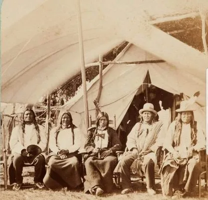 Sepia photograph of five Lakota chiefs seated before a canvas tent, named in the post as Gall, Crawler, Low Dog, Running Antelope and Rain in the Face.