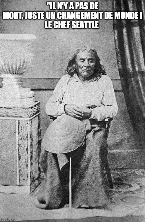 Photographie ancienne en noir et blanc d'un aîné aux longs cheveux, assis, un chapeau sur les genoux. Texte : « Il n'y a pas de mort, juste un changement de monde ! Le chef Seattle ».