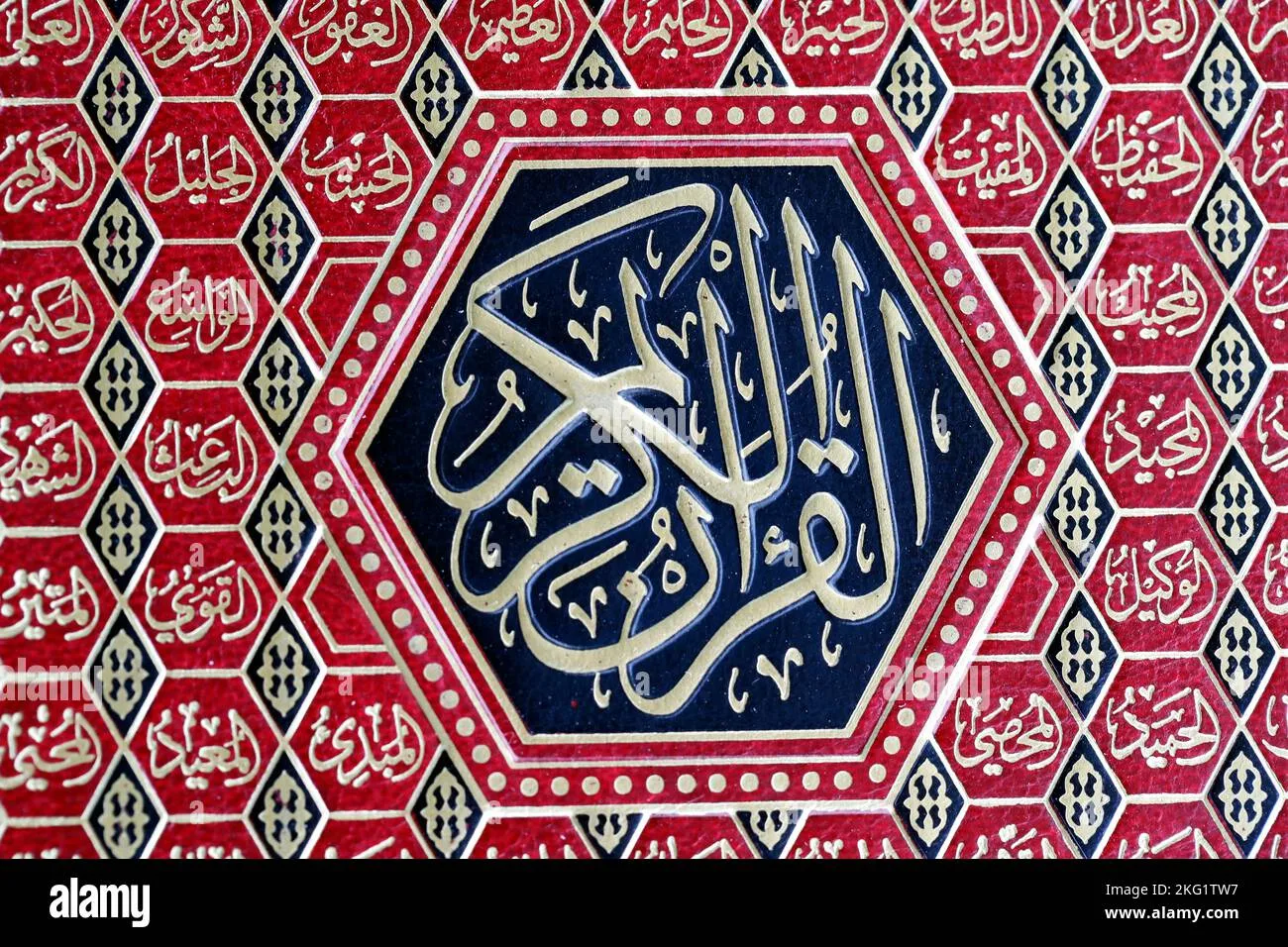 غلاف مصحف أحمر مزخرف، في وسطه شكل سداسي أسود كُتب عليه بالخط الذهبي «القرآن الكريم»، وحوله خلايا سداسية تحمل أسماء الله الحسنى.