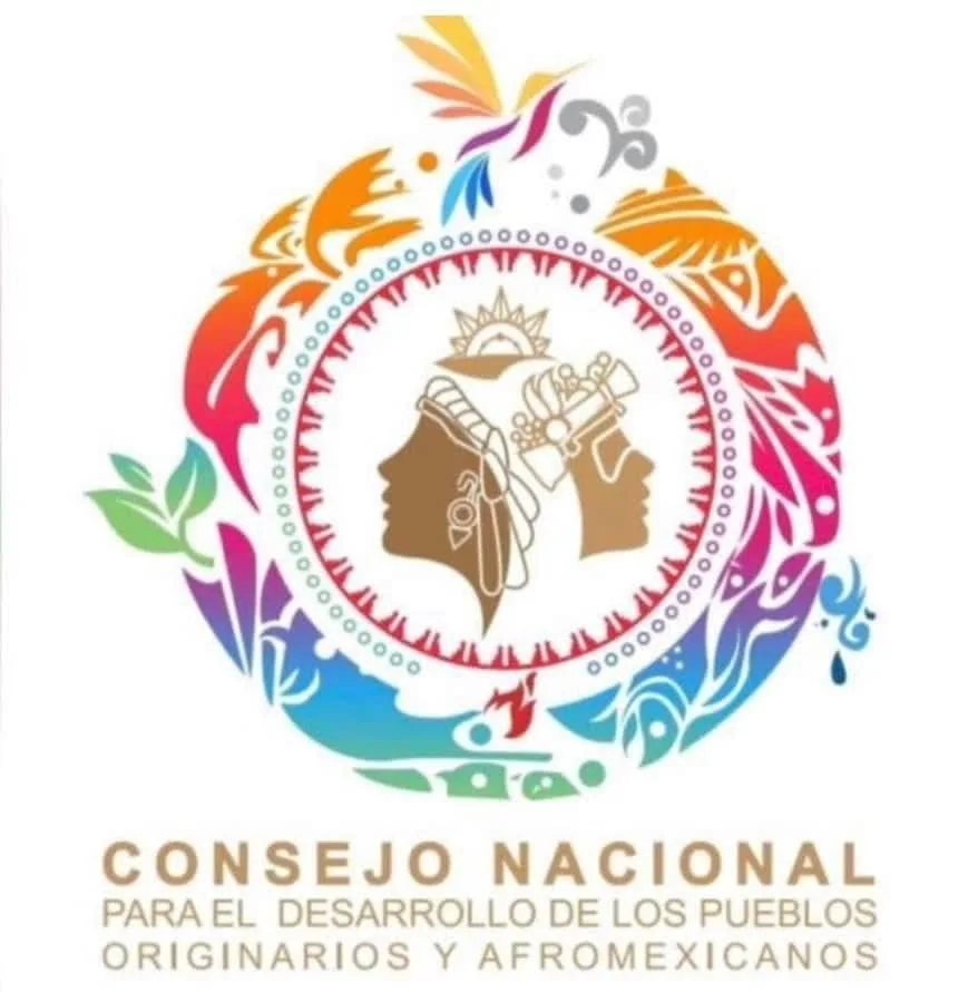 Colorful circular logo with two brown profile faces, one in a headwrap and one in a headdress, ringed by vivid plant, bird and water shapes. Text: Consejo Nacional para el Desarrollo de los Pueblos Originarios y Afromexicanos.